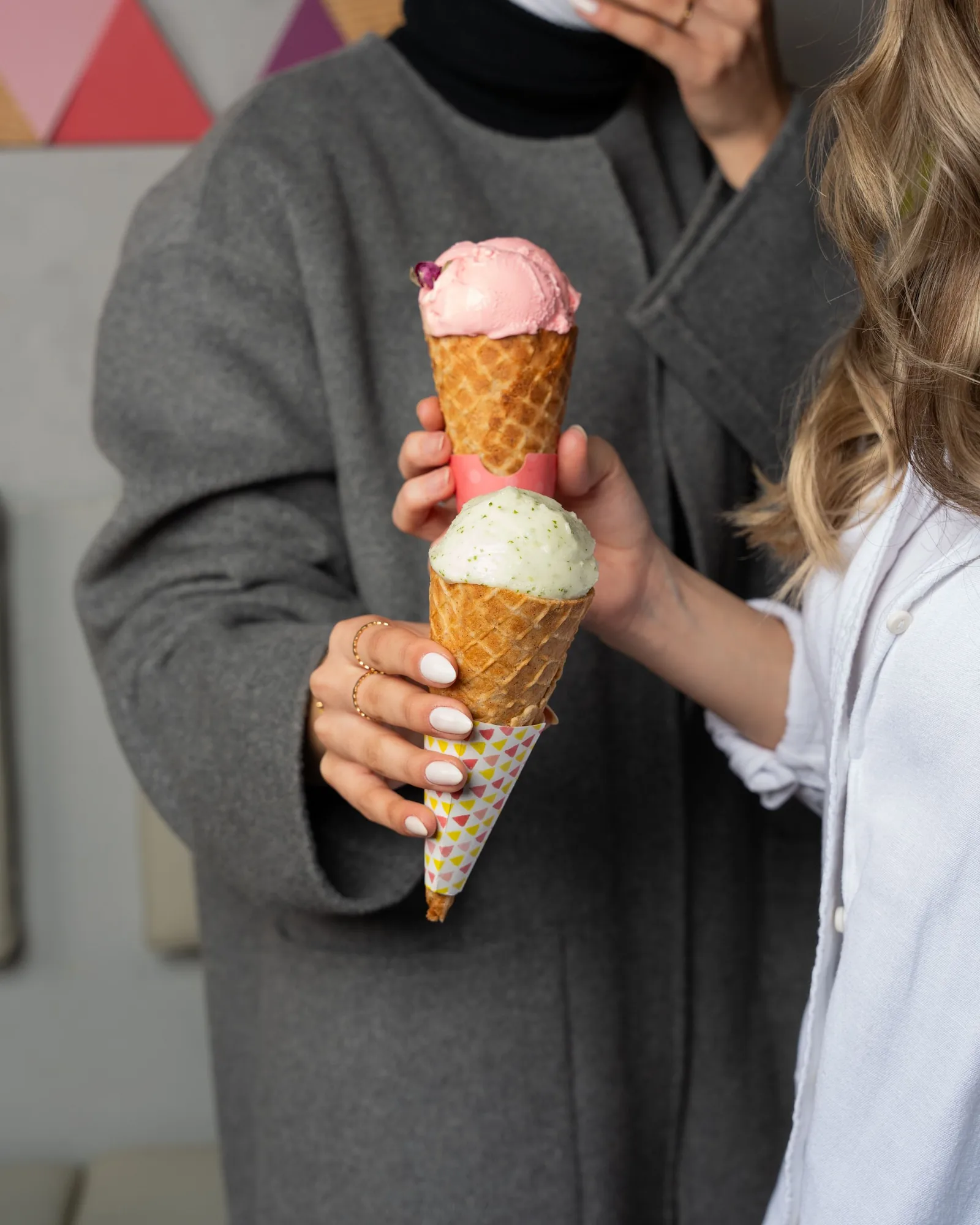 Two friends holding up ice cream cones